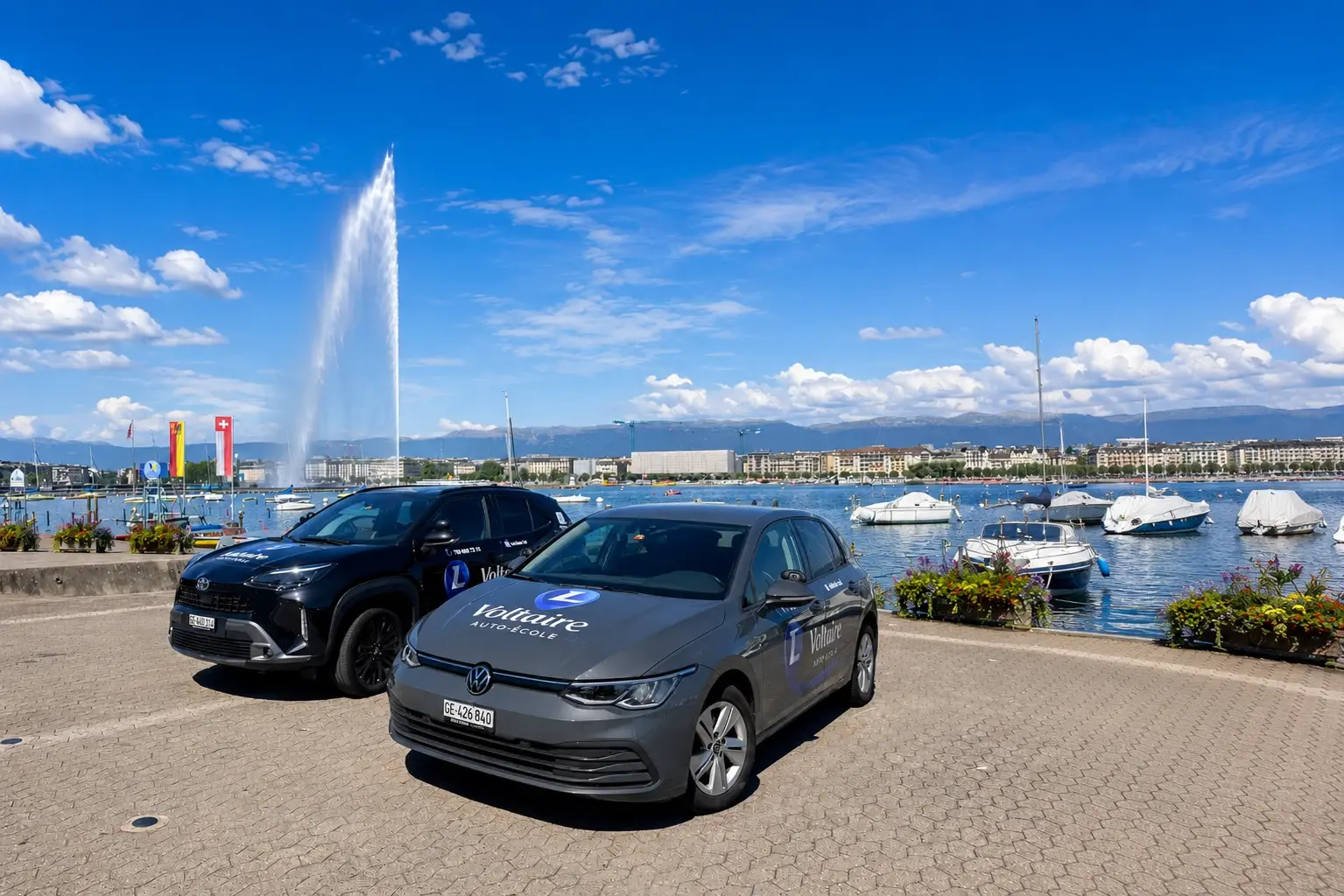 Voitures de l'Auto-École L Voltaire devant le Jet d'eau à Genève